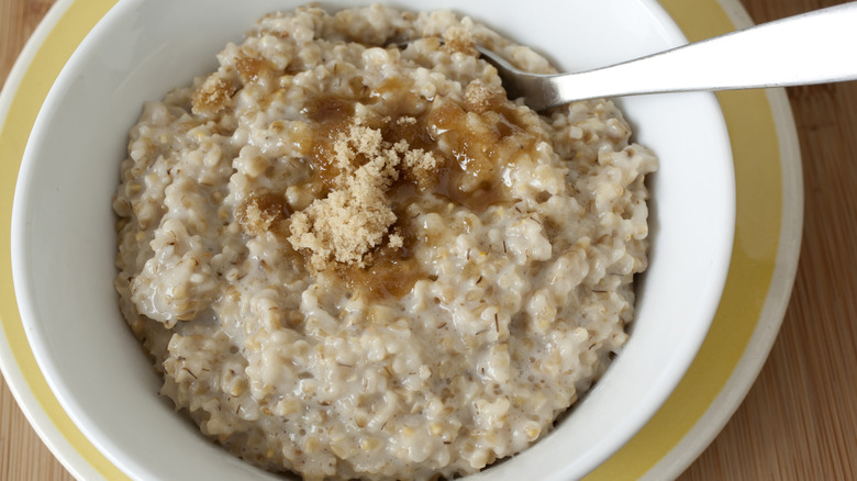 White bowl of oatmeal with brown sugar.