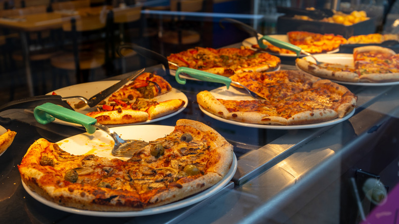Pizzas displayed on buffet line