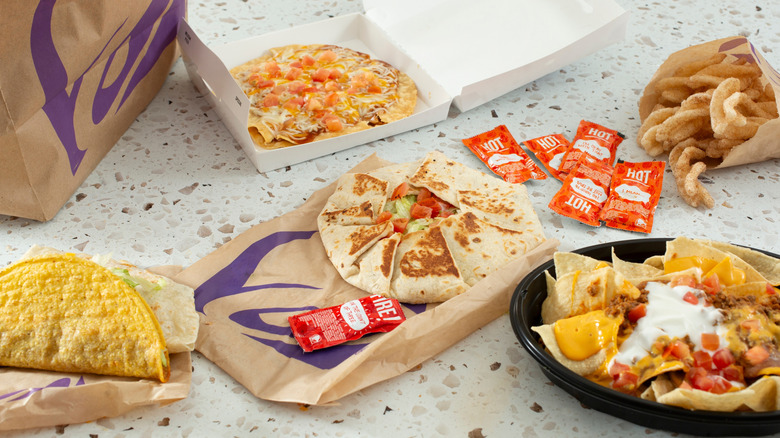 A Taco Bell meal with five options spread out on speckled counter or table top.