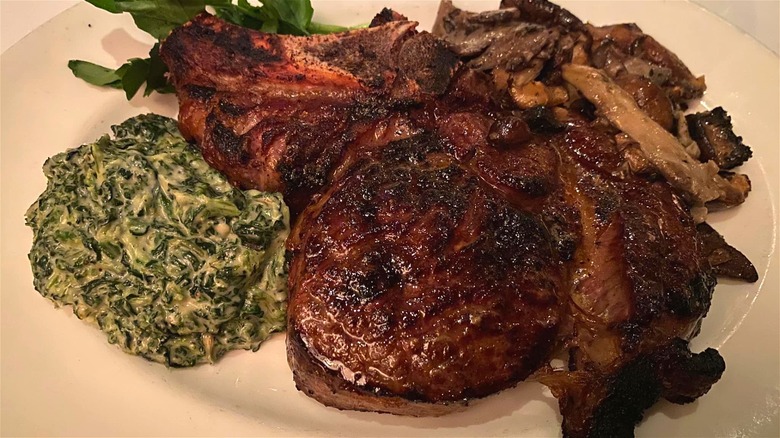 A bone-in ribeye steak with sides from The Capital Grille.