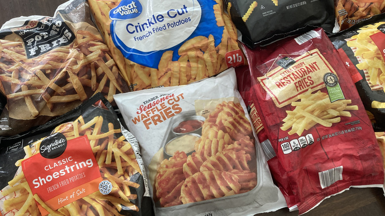 Multiple bags of frozen store-brand french fries on a table