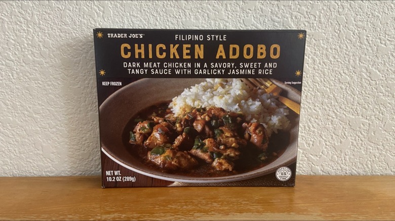A package of Trader Joe's frozen Filipino chicken adobo against a wall
