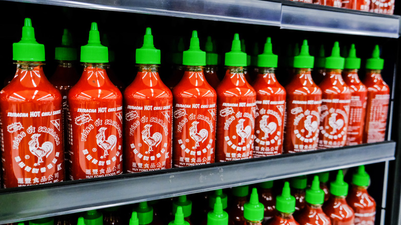 Sriracha bottles with green lids on store shelves