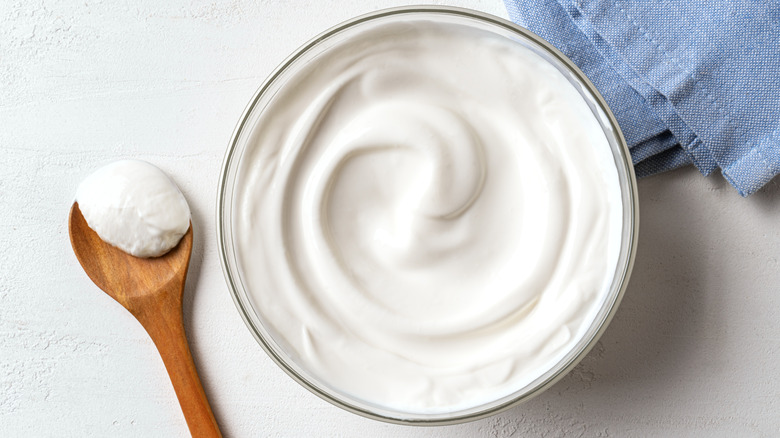 Bowl of Greek yogurt next to a wooden spoon