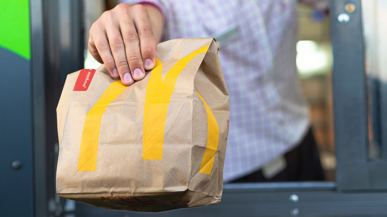 Hand holding McDonald's bag