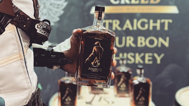 person holding Assassin's Creed whiskey