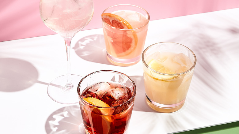 Four cocktails on pink background