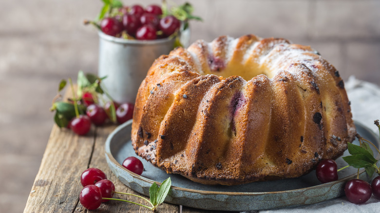 Bundt cake with cherries on metal slab