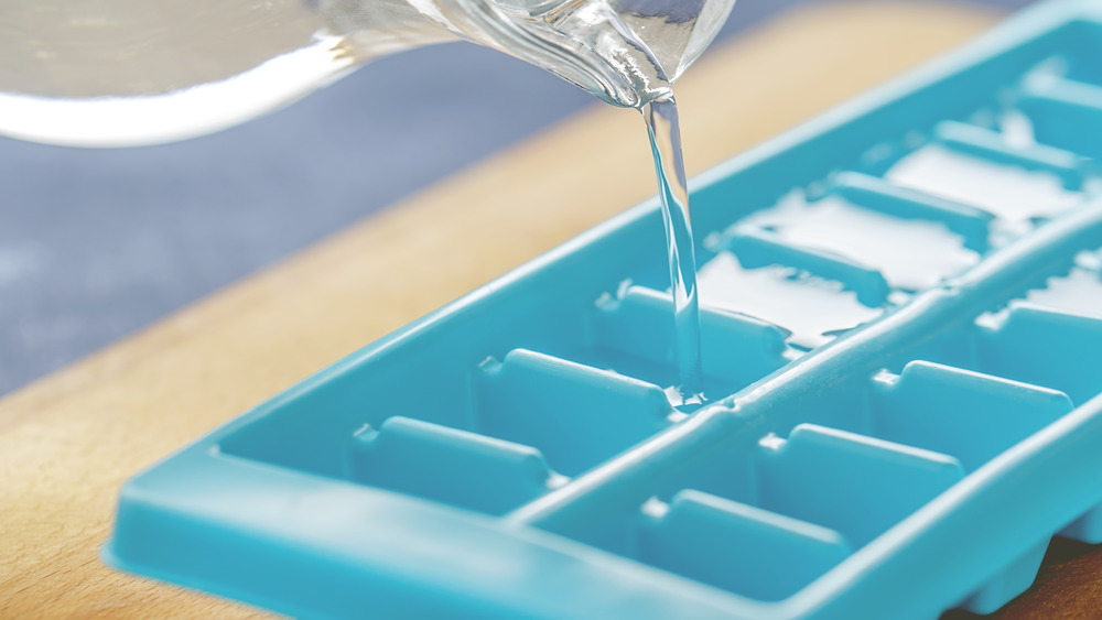 Water being poured into ice cube tray