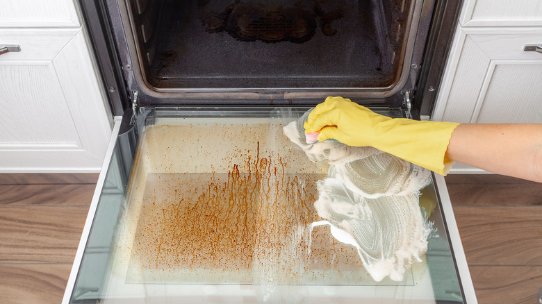 Person cleaning oven