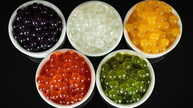 Various colored tapioca pearls in white bowls