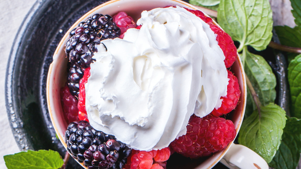 Whipped cream over raspberries and blackberries