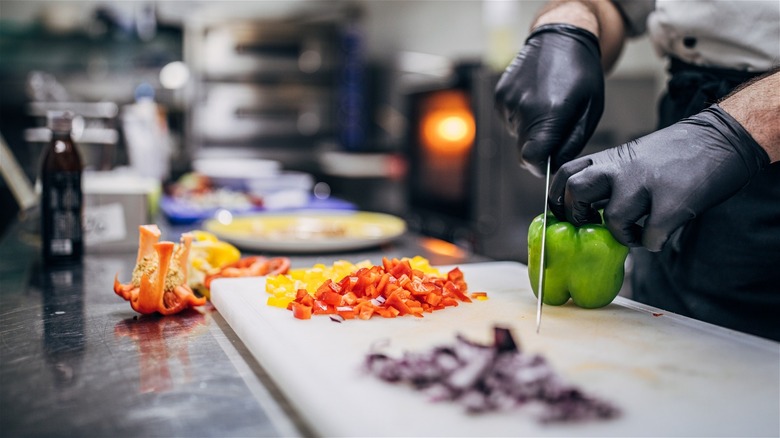 a cook preparing vegetables in a professional kitchen