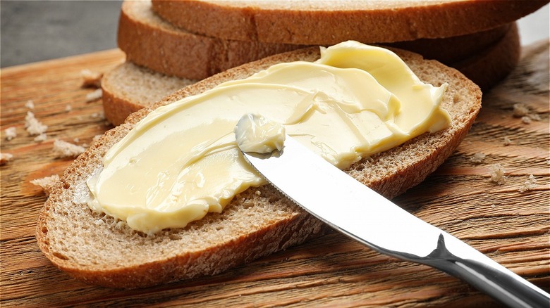 knife spreading butter on bread