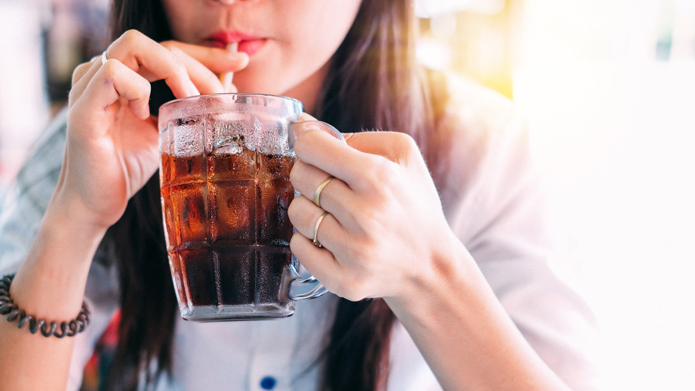 Woman taking a drink of a soda 