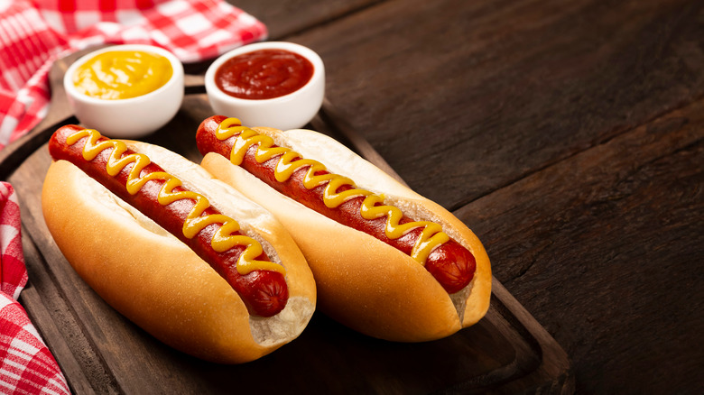 Hot dogs on a table with mustard