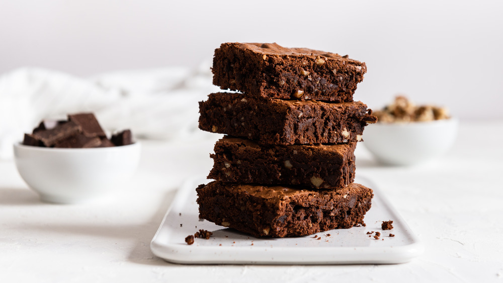 A stack of chocolate brownies on a white plate
