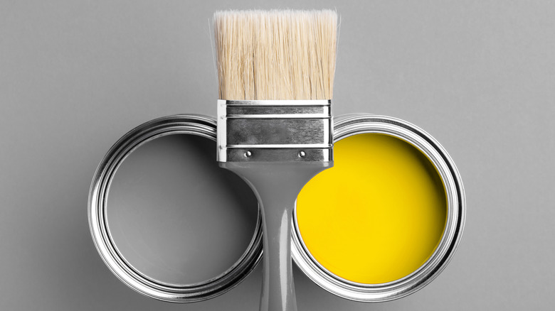 Two cans of paint with paintbrush