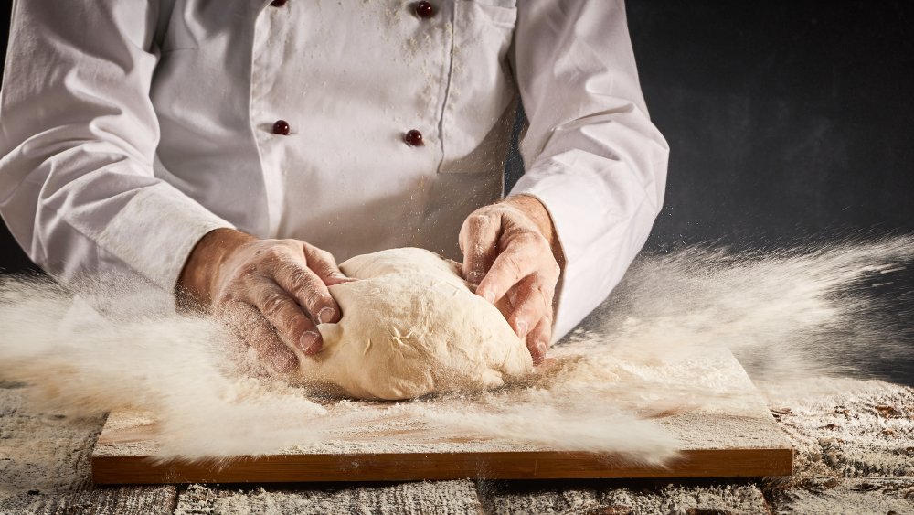 Chef kneading pizza dough