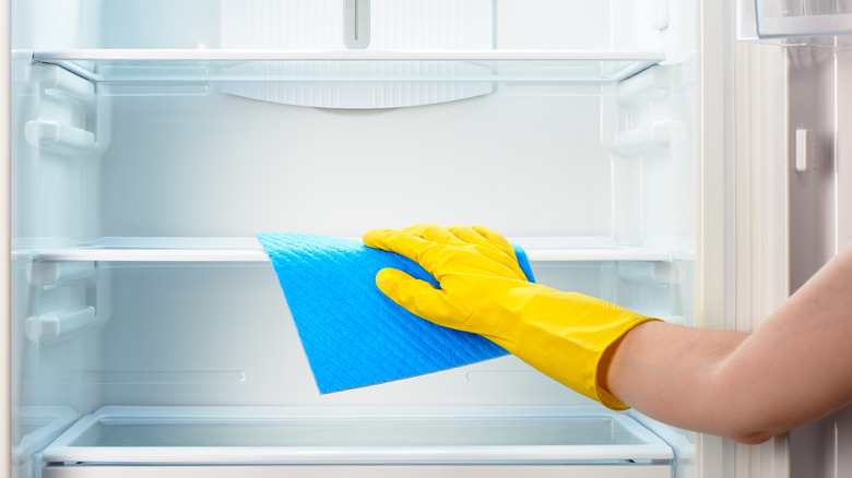 Person wiping out refrigerator