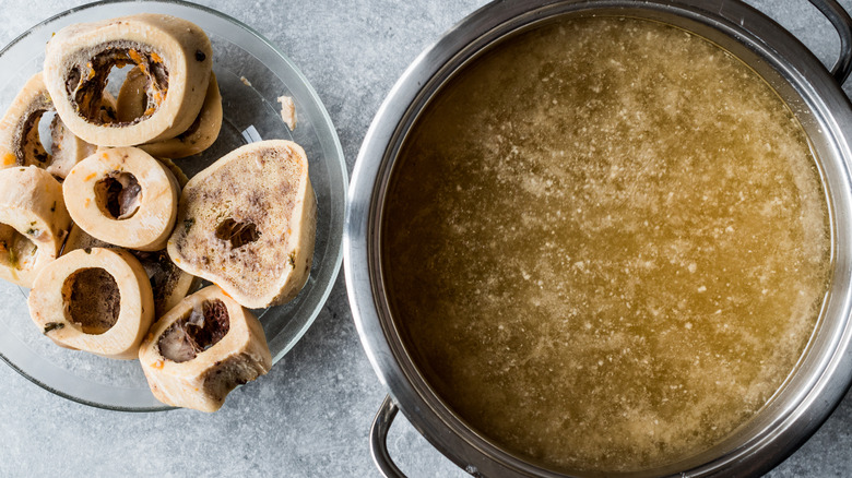 Sliced bones in a bowl next to a pot of bone broth.