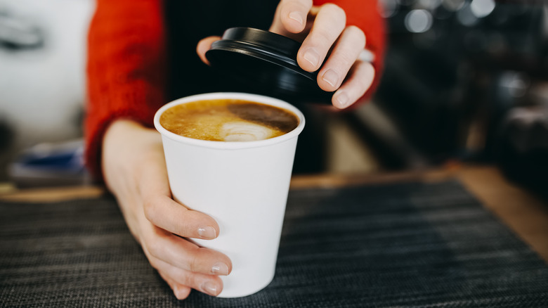 Barista holding a takeaway coffee