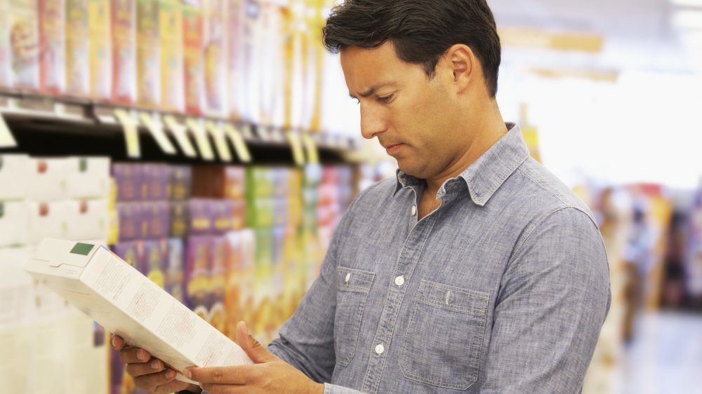 Man shopping for cereal in supermarket aisle