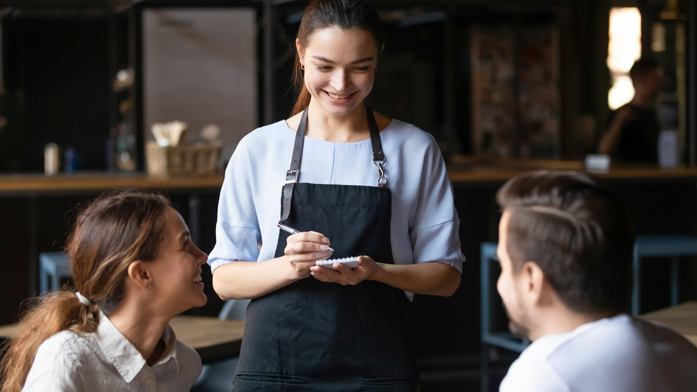 Waiter taking order at restaurant