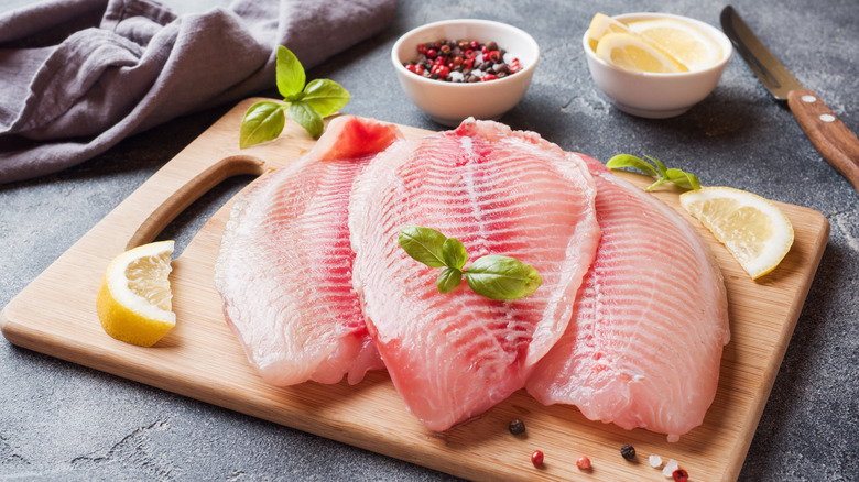 Fresh tilapia on cutting board