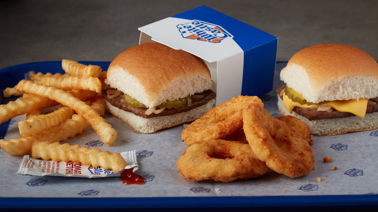 A tray of White Castle hamburgers, fries, and onion rings