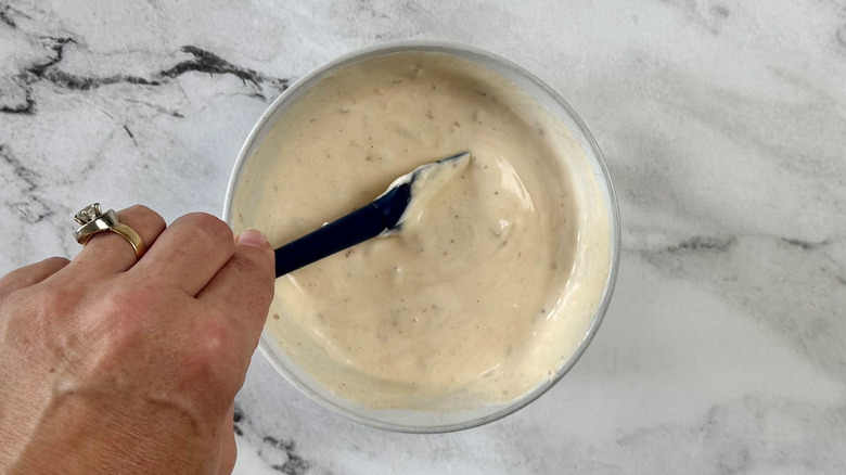 Hand mixing chipotle cream sauce in bowl