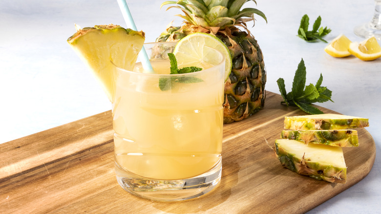 Pineapple cocktail with mint garnish and sliced pineapple.