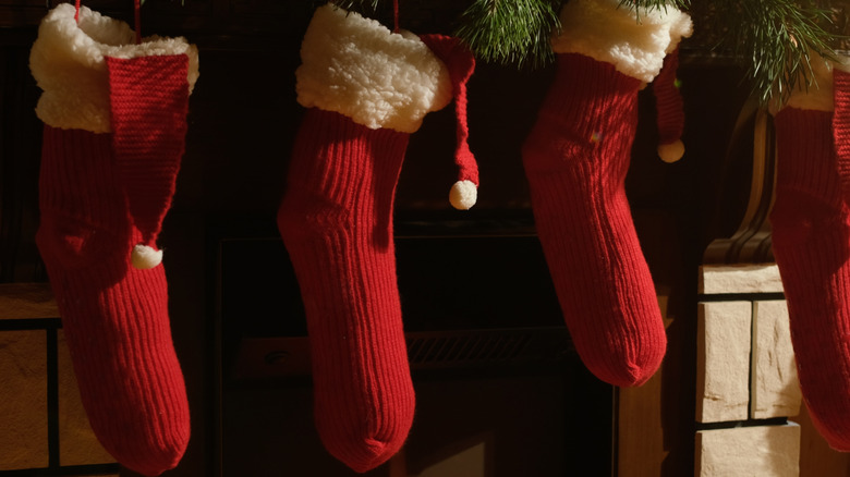 Row of red knit stockings hanging from a mantle
