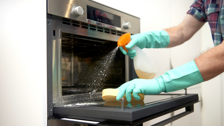 Person cleaning an oven