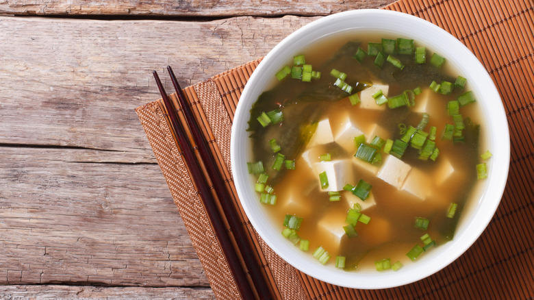 bowl of miso soup with chopsticks