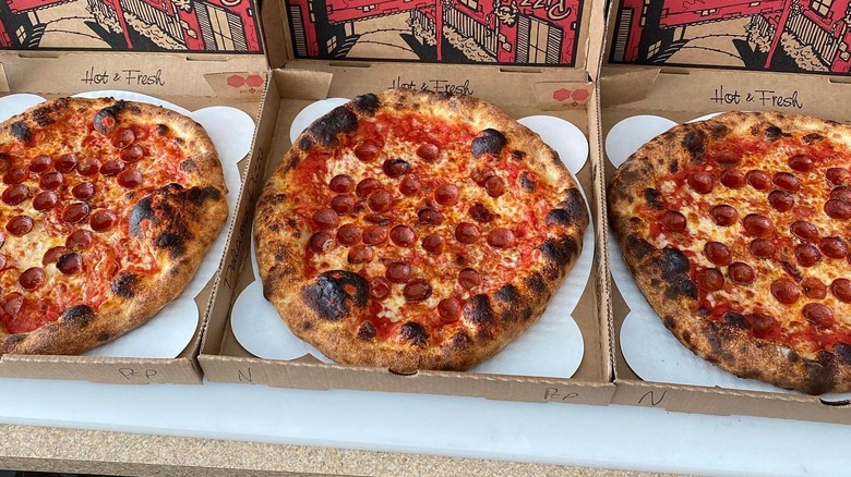 a row of pepperoni pizzas