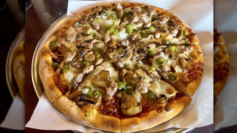 The Super, a large pizza with mushrooms and veggies on metal tray at Eugene's Pizza restaurant in Montana