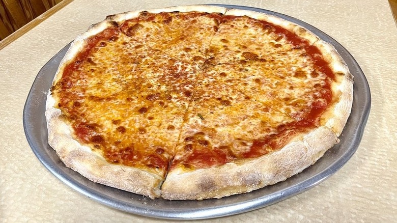 a large New York style pizza on metal pizza tray and Louie & Ernie's Pizza restaurant in New York