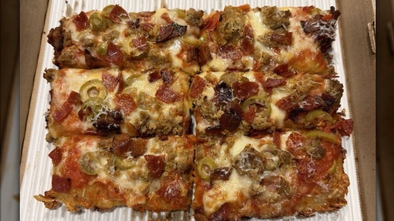 a meat lover's pizza cut into small rectangles in takeout box from Kitchen Window restaurant in Oregon