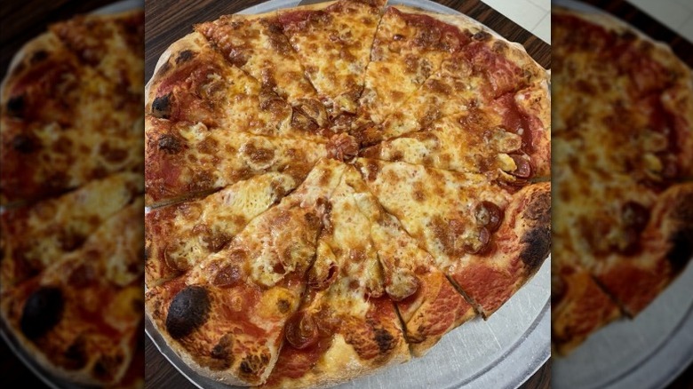 a large pepperoni pizza cut into triangles on metal pizza tray at Fiori's Pizzaria in Pennsylvania