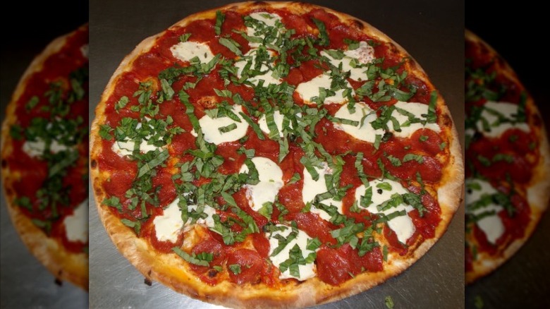 Pizza with double pepperoni, fresh mozzarella, and shredded fresh basil