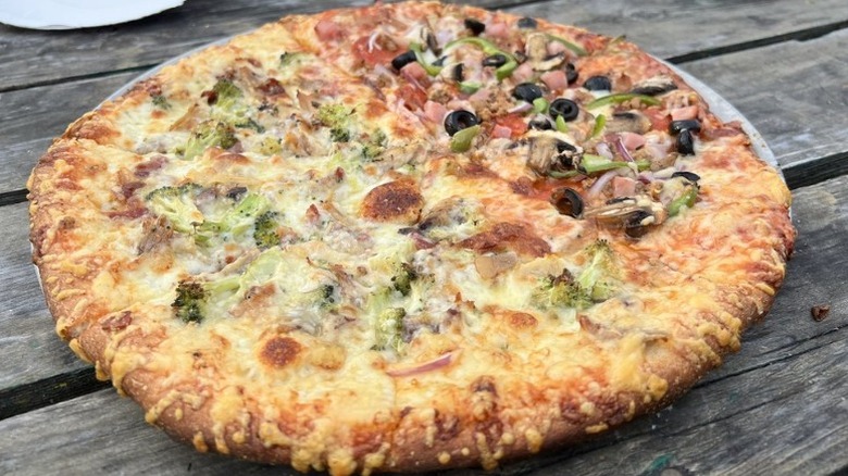 large half pepperoni and half mushroom pizza on wooden table at Parker Pie Company in vermont