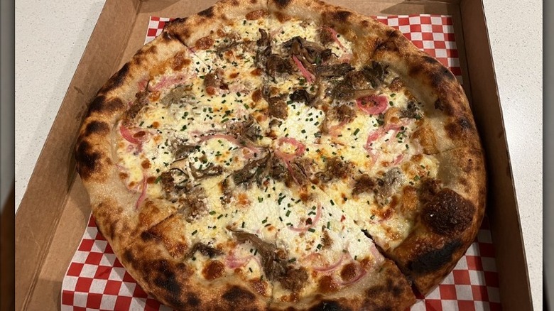 a veggie pizza with sausage in takeout box from Stevie's Famous restaurant in Washington