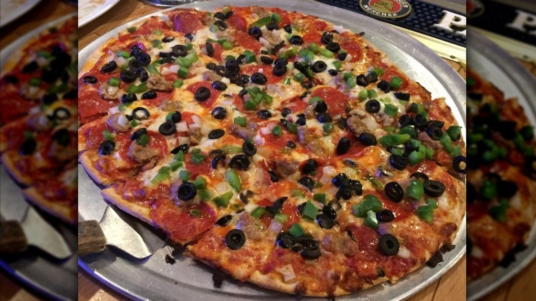 pepperoni sausage with mushroom and onions on metal pizza tray cut in squares at Random Lake Pizzeria in Wisconsin