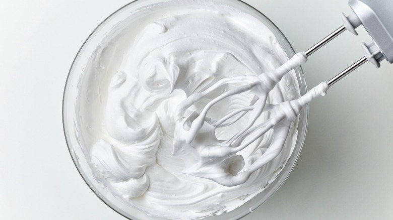 whipping cream in a bowl with hand mixer