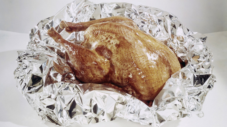 a pale roasted chicken in aluminum foil 