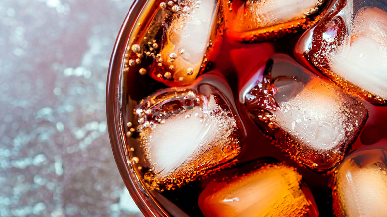 A close up of cola and ice in a glass