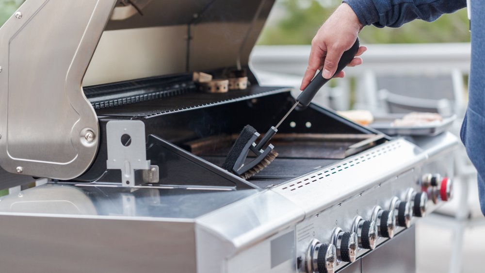 Gas grill being cleaned