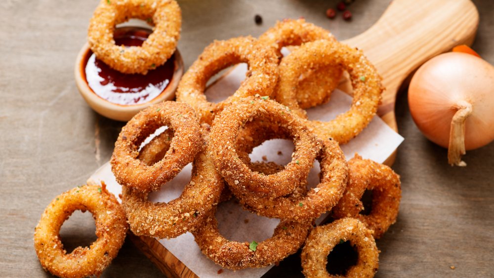 golden brown fried onion rings on a cutting board