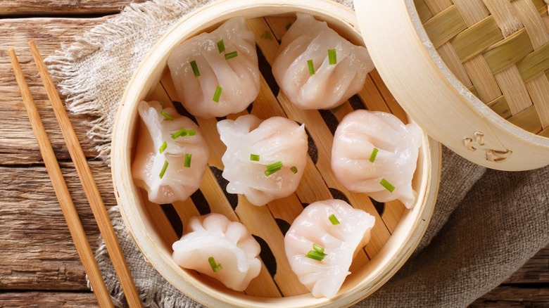 Dumplings in bamboo container with chopsticks 